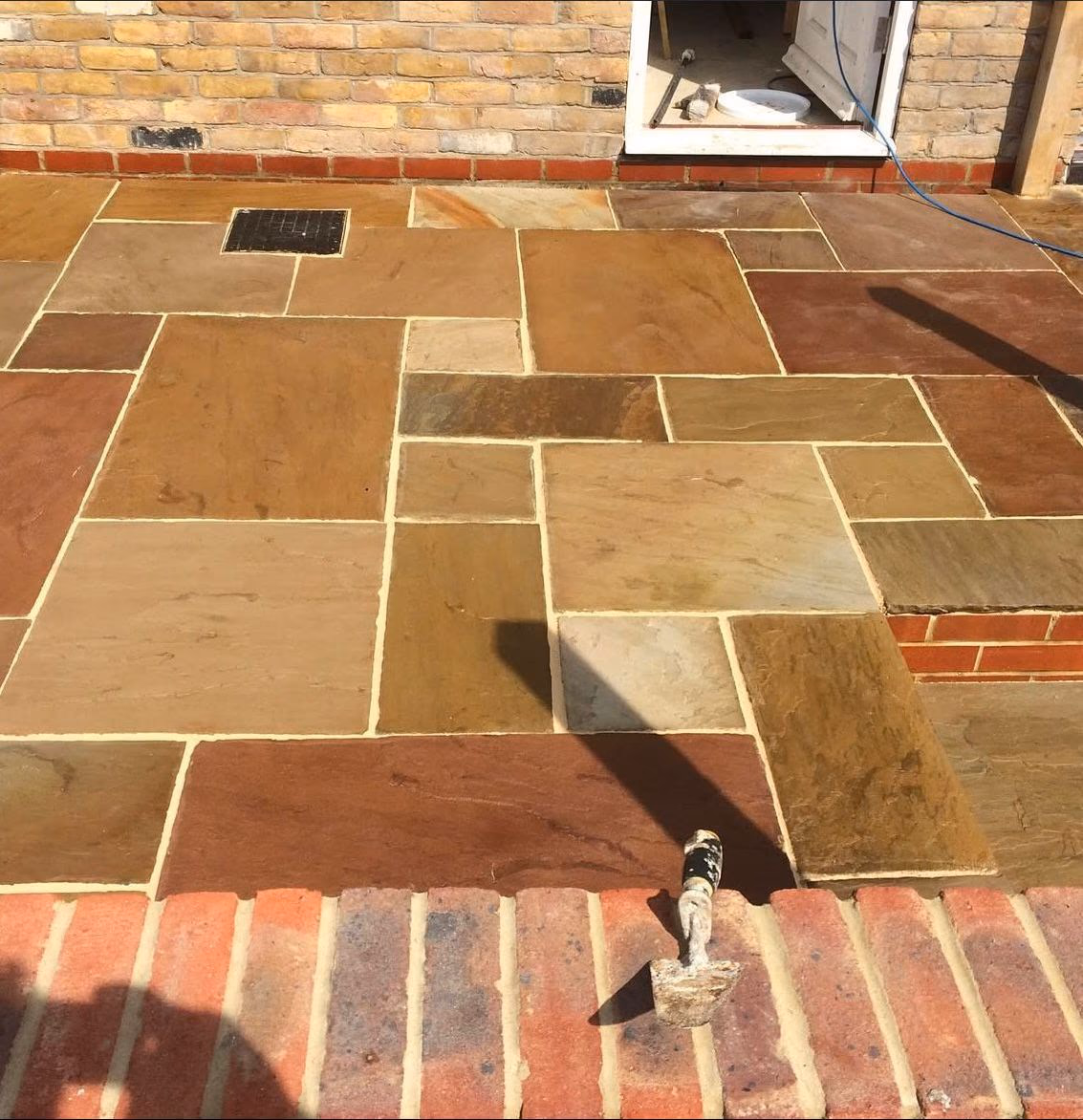 Sandstone patio with brick edging (2)